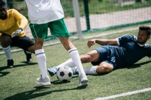 multiethnic soccer players playing soccer on pitch together