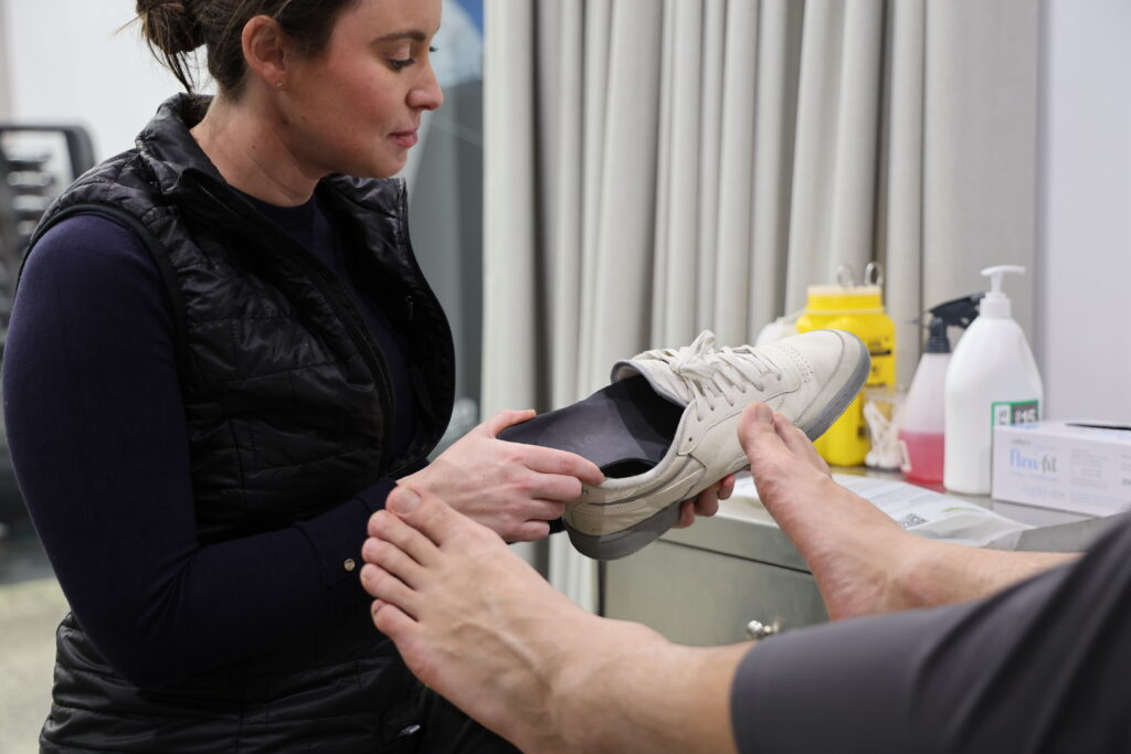 Podiatrist fitting orthotics for a patient at Melbourne CBD Physio