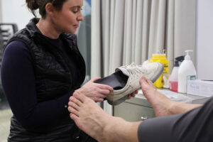 Podiatrist fitting orthotics for a patient at Melbourne CBD Physio